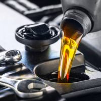 Pouring motor oil for motor vehicles from a gray bottle into the engine, ,  oil change,  auto repair shop, service,