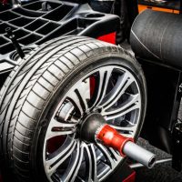 A modern alloy car wheel on the wheel balancing machine in an auto repair shop.