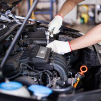 Hands of car mechanic in auto repair service.